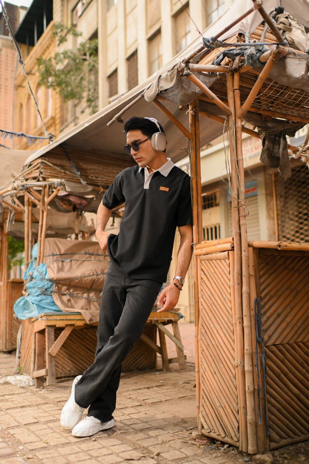 "Textured black knit polo with oversized fit, ideal for minimalist or modern looks"