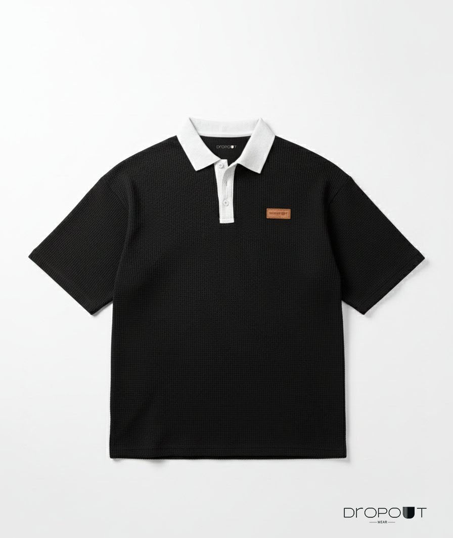 "Oversized black waffle knit polo shirt with textured fabric and relaxed fit"
