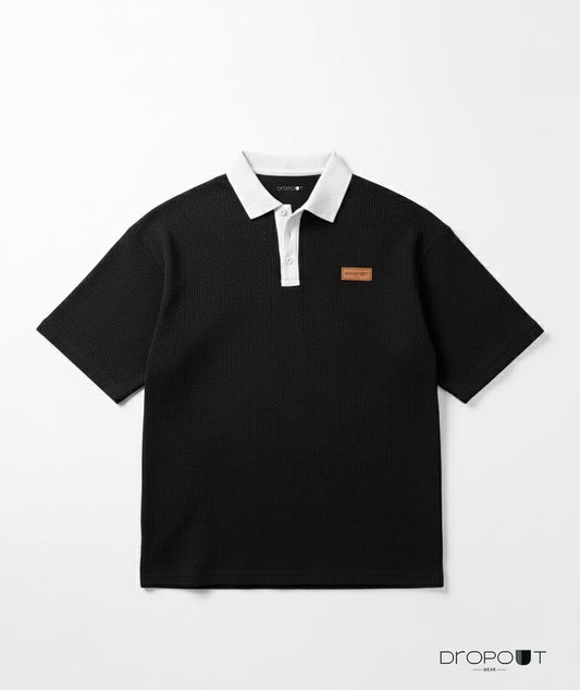 "Oversized black waffle knit polo shirt with textured fabric and relaxed fit"