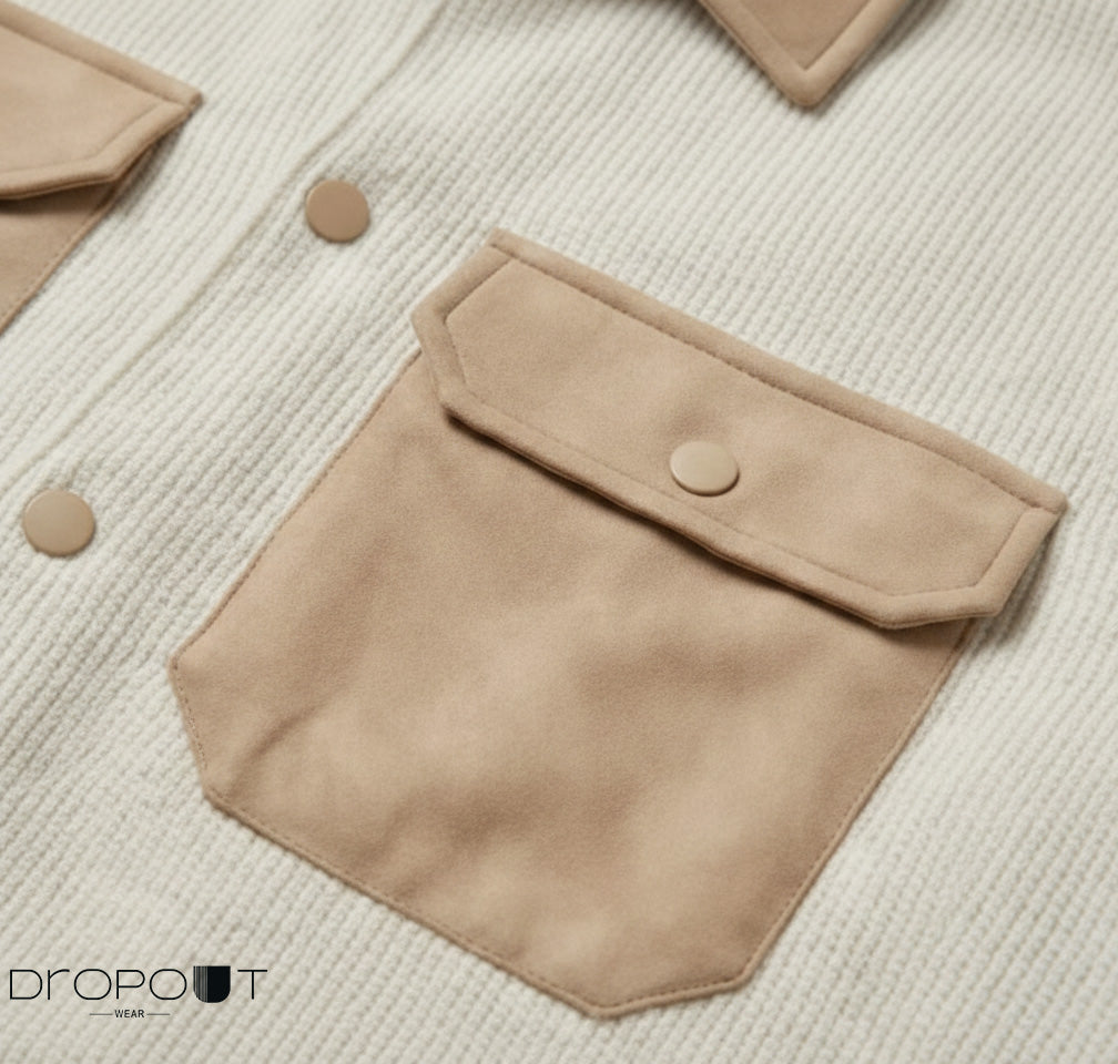 “Knitted camel shacket with soft suede detailing on the collar, cuffs, hem, and pockets, accented by two handmade suede-covered brass buttons.”